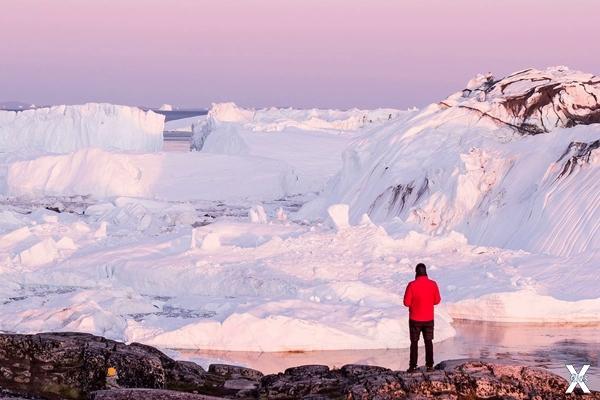 Лед Гренландии, местами достигающий к...