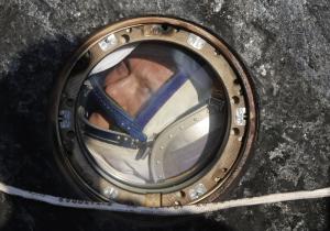 Российский космонавт Олег Артемьев выглядывает из капсулы космического корабля Союз ТМА-12